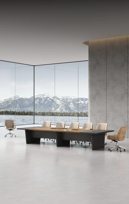 Modern conference room with a large oval table and chairs, featuring a scenic view of mountains through large windows.