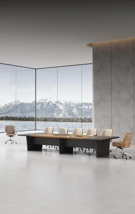 Modern conference room with a large oval table and chairs, featuring a scenic view of mountains through large windows.