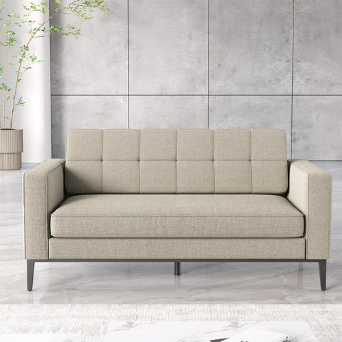 A modern two-seater sofa in light beige textured fabric with a tufted backrest and dark metal legs, set against a gray paneled wall and light marble floor.